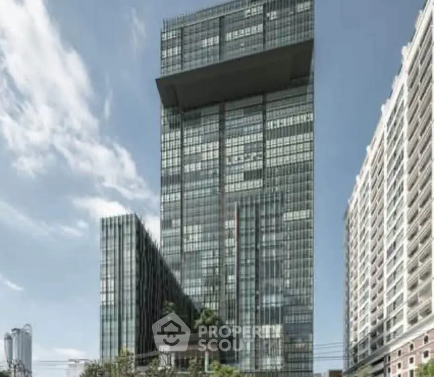 Modern high-rise building with sleek glass facade and urban surroundings.