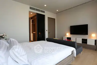 Modern bedroom with sleek design, featuring a large bed, wall-mounted TV, and stylish decor.