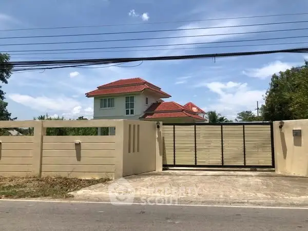 Charming suburban house with red-tiled roof and gated entrance, perfect for family living.