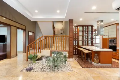 Luxurious open-plan living area with modern kitchen and elegant staircase