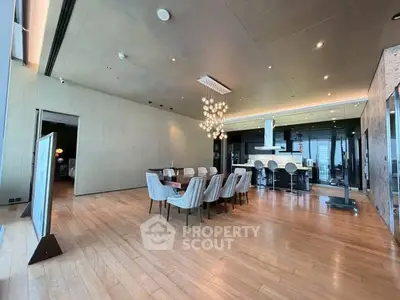 Luxurious open-plan dining and kitchen area with modern lighting and sleek design.