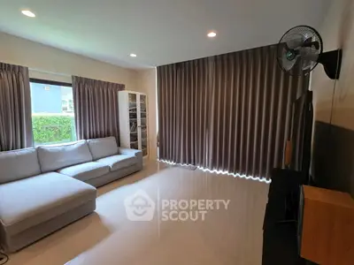 Spacious living room with modern sofa and large windows for natural light.
