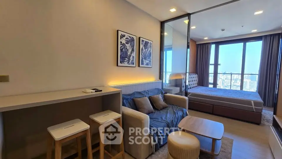 Modern studio apartment with cozy living area and stunning city view