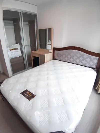 Modern bedroom with stylish bed and mirrored wardrobe in a cozy apartment.