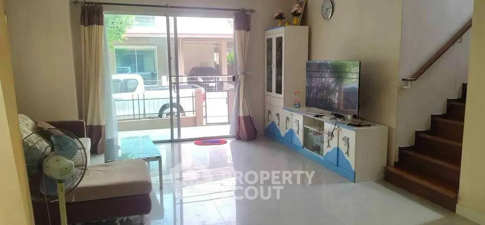 Spacious living room with modern decor and large sliding glass doors leading to balcony.