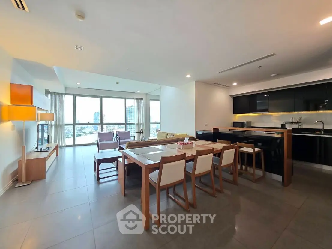 Spacious open-plan living and dining area with modern furnishings and large windows.