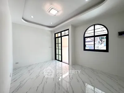 Spacious modern living room with marble flooring and large windows for natural light.