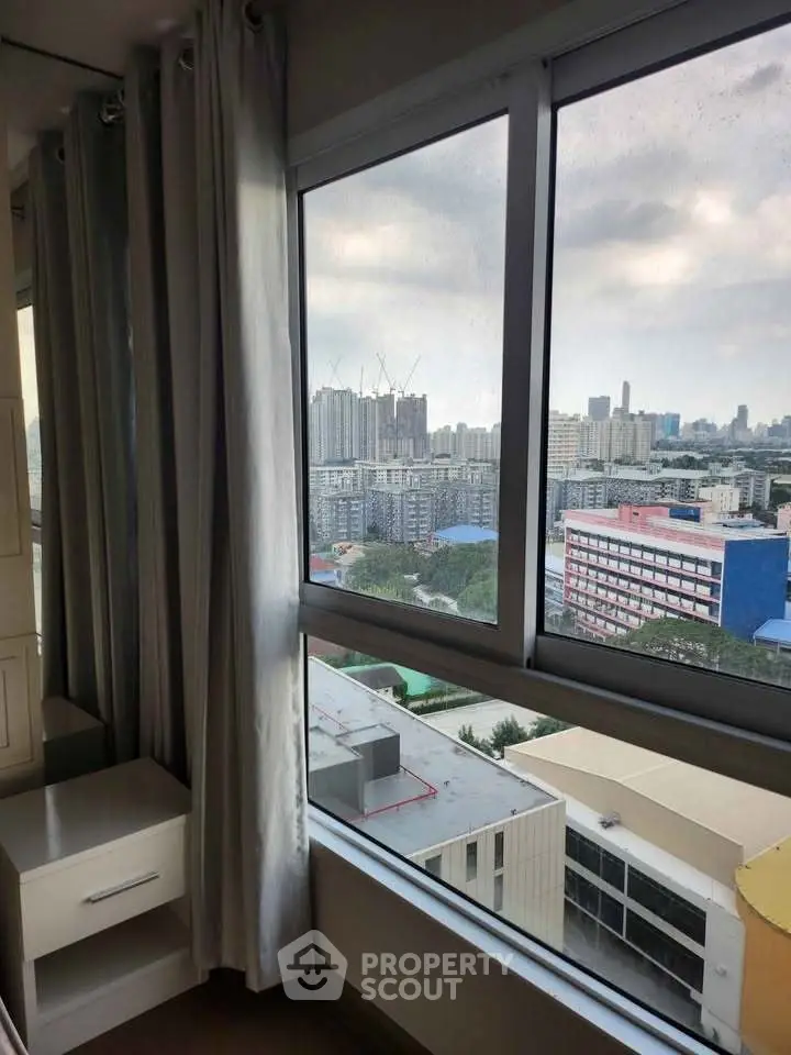 Stunning city view from a high-rise apartment window, showcasing urban skyline and modern living.