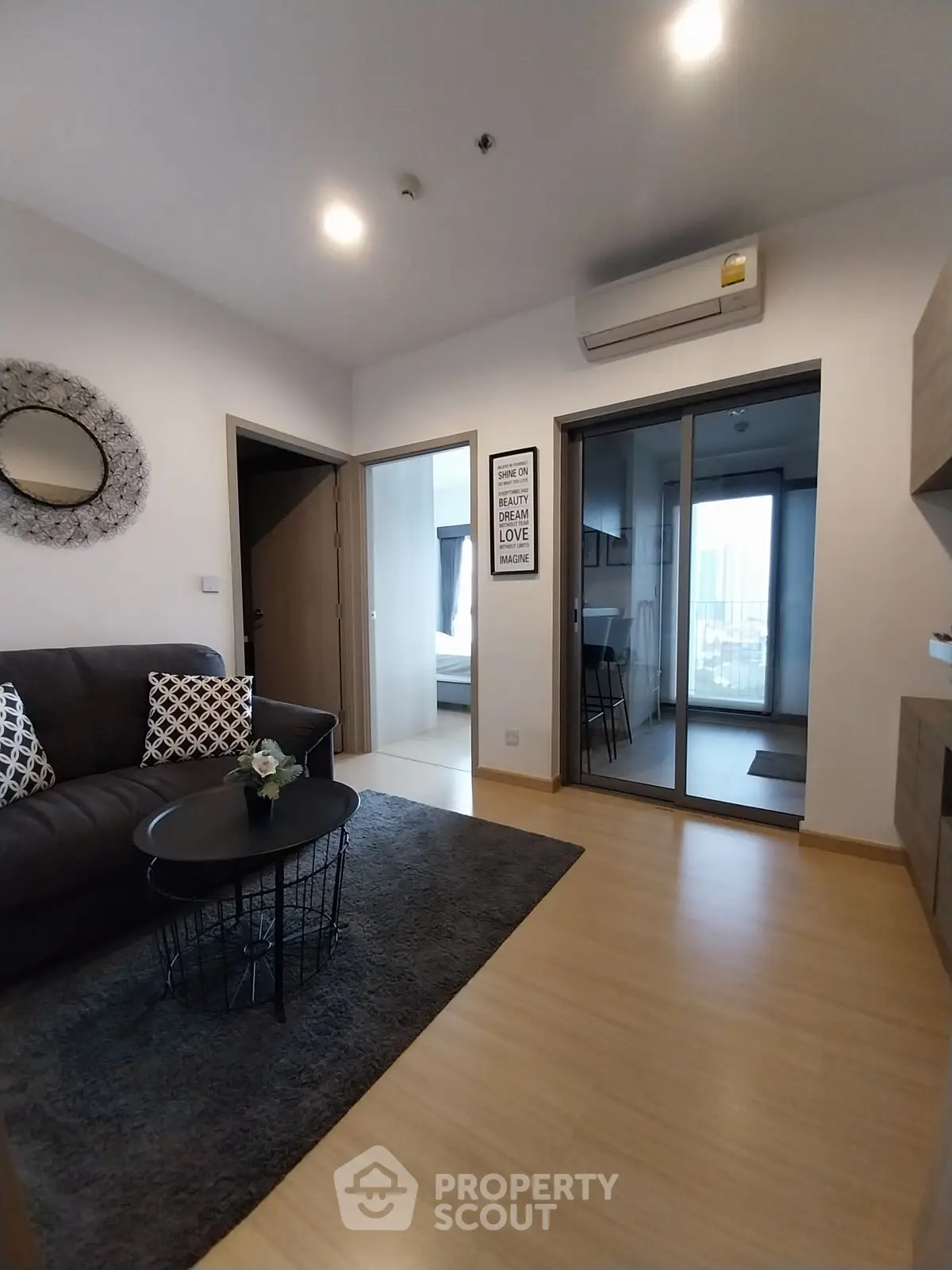 Modern living room with stylish decor and open view to kitchen and bedroom