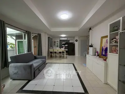 Spacious living room with modern decor and large windows in a stylish apartment.