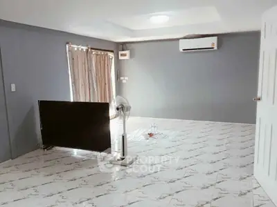 Spacious living room with modern air conditioning and stylish tiled flooring.