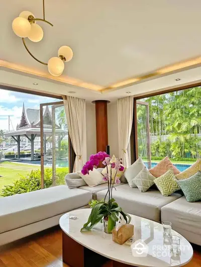 Luxurious living room with large windows and garden view, featuring elegant decor and modern lighting.