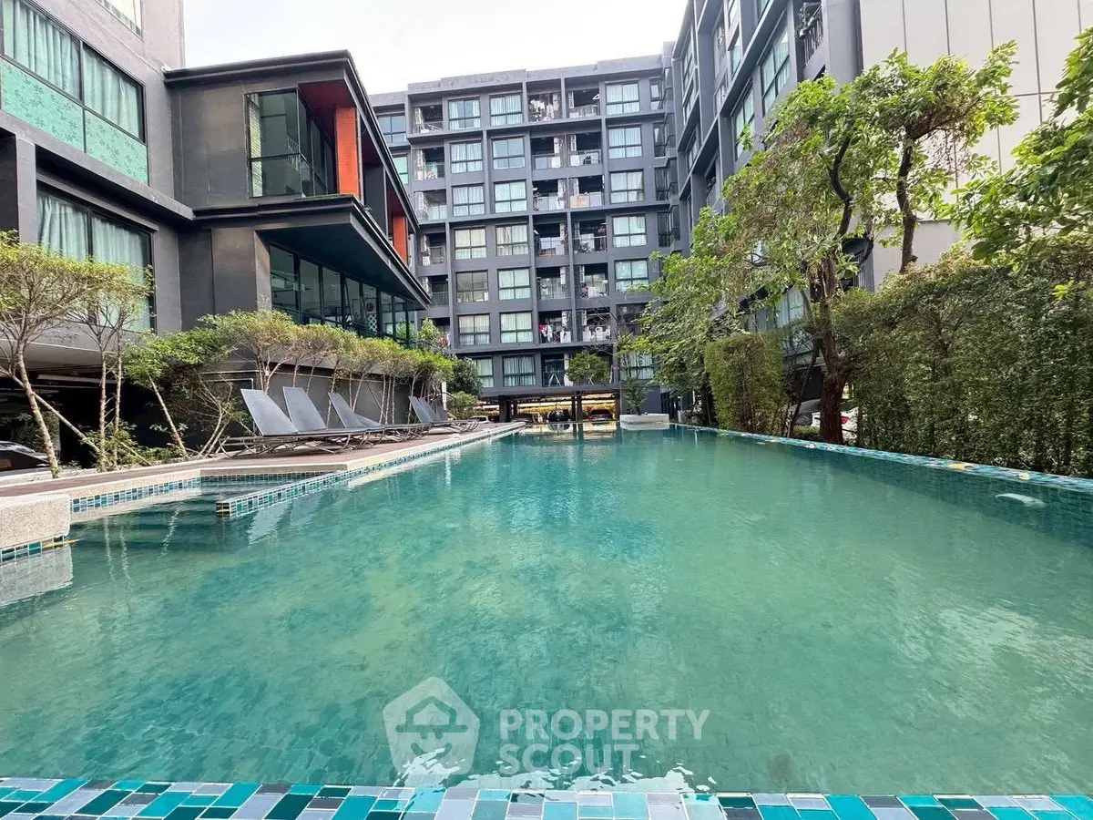 Luxurious apartment complex with stunning outdoor pool and modern architecture.
