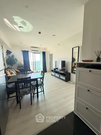 Spacious modern living room with dining area and large windows in a stylish apartment.