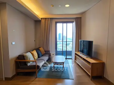 Modern living room with balcony view, stylish furniture, and natural lighting.