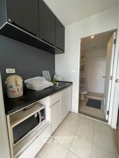 Compact kitchen with modern cabinets and adjacent bathroom