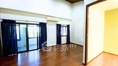 Spacious room with wooden flooring and large windows, perfect for natural light.