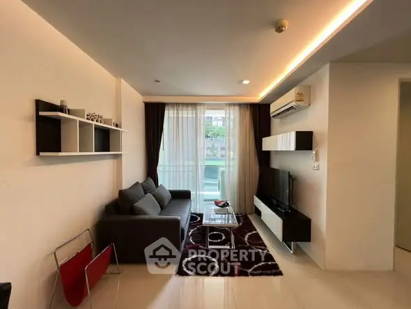 Modern living room with sleek furniture and stylish decor, featuring a cozy sofa and large window.