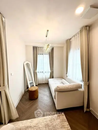 Elegant living room with plush white sofa and stylish chandelier, perfect for modern comfort.