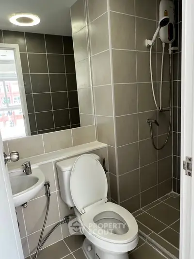 Modern bathroom with shower and toilet in sleek tiled design
