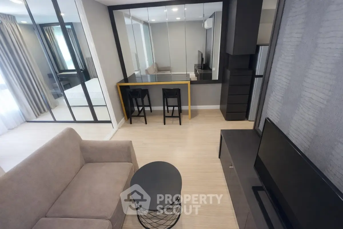 Modern living room with sleek furniture and mirrored wall for spacious feel