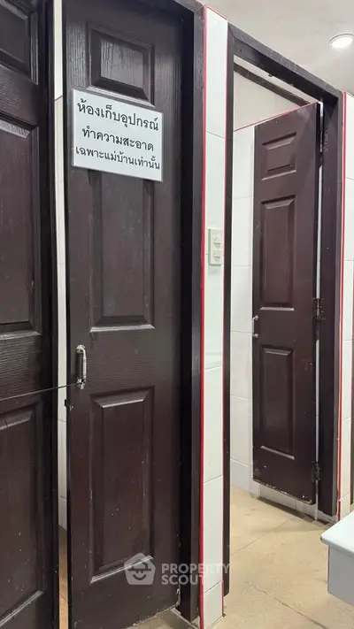 Storage room with dark wooden doors in a tiled interior space