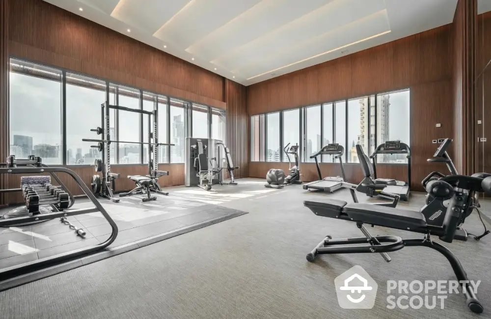 Luxurious high-rise gym with panoramic city views and modern fitness equipment.