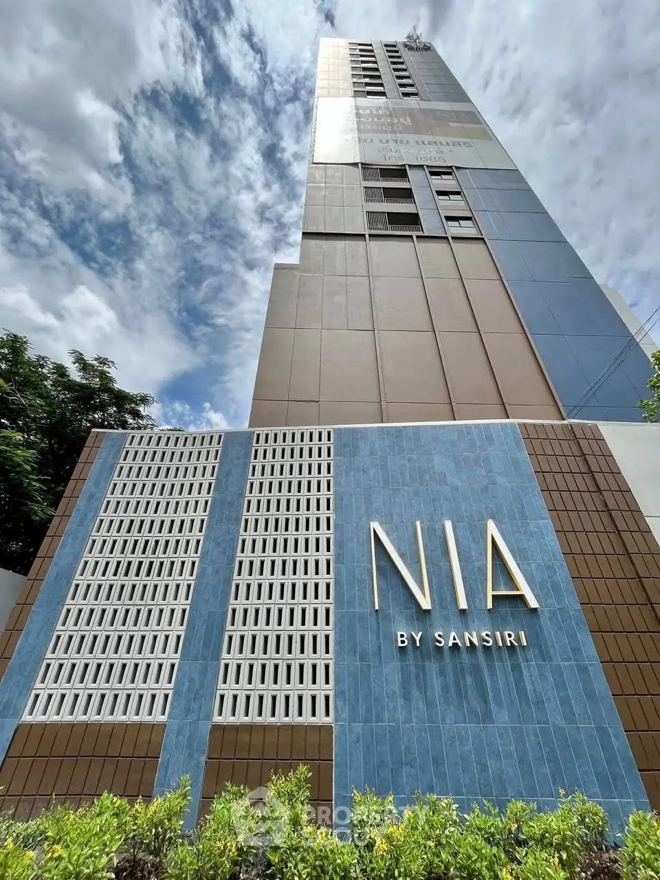 Modern high-rise building with sleek architectural design and lush landscaping