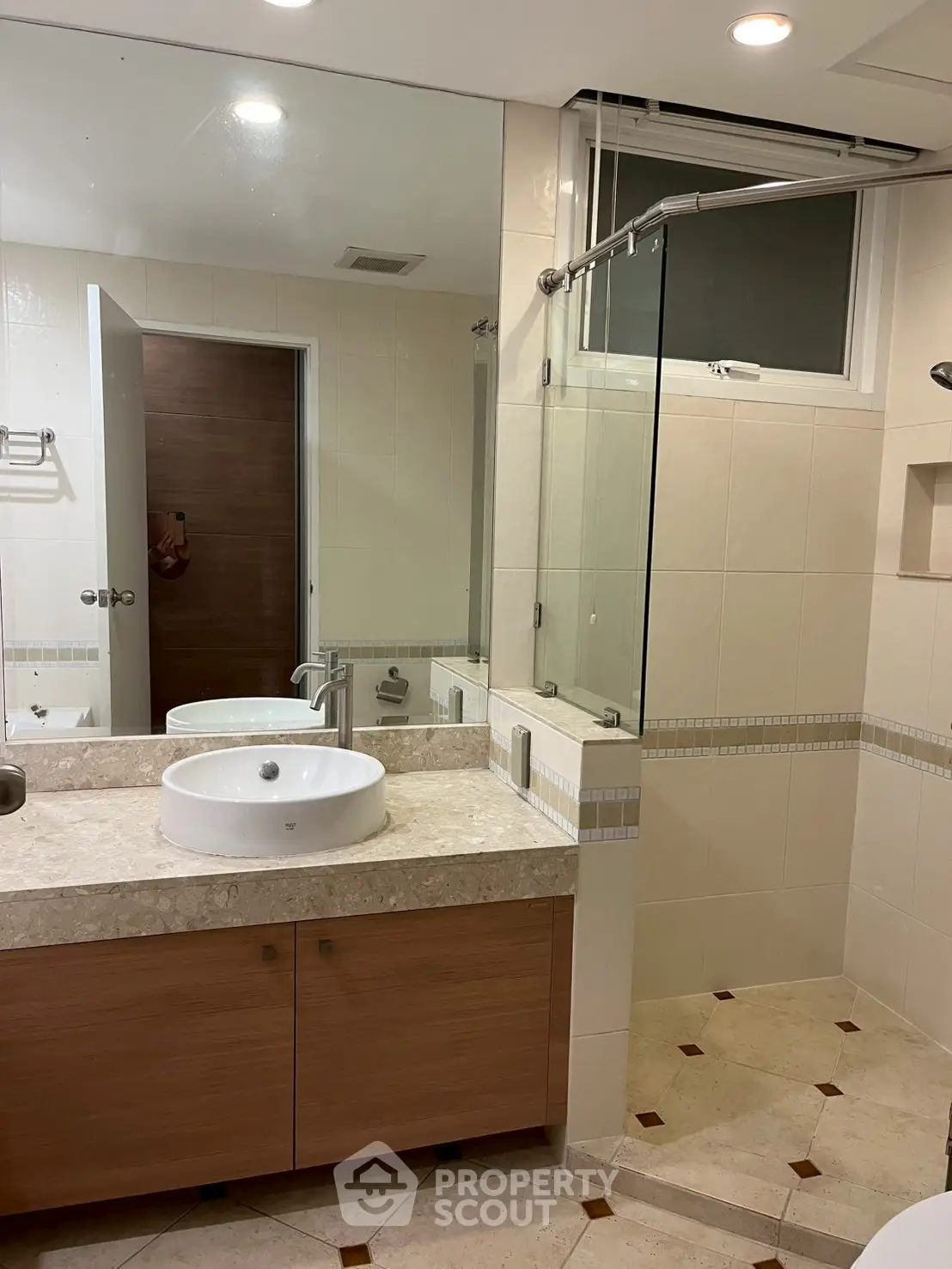 Modern bathroom with glass shower and elegant vanity in stylish home.