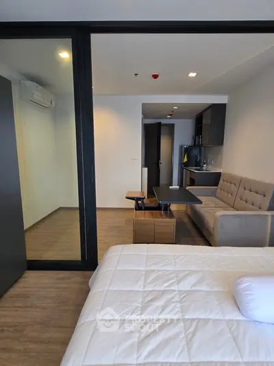 Modern studio apartment with cozy living area and sleek kitchen design.