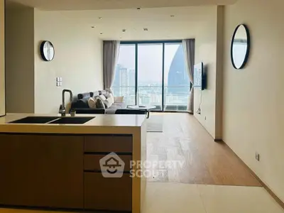 Modern living room with city view, featuring open kitchen and stylish decor.