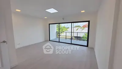 Spacious modern living room with large windows and balcony view