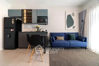 Modern open-layout kitchen and living room with stylish decor and natural light.