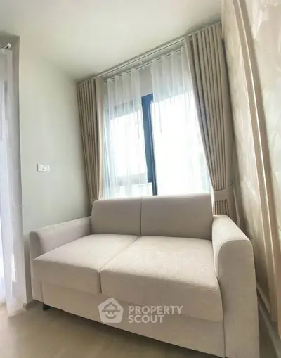 Cozy living room with modern beige sofa and elegant curtains in a bright apartment.