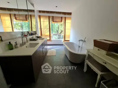 Luxurious bathroom with modern fixtures and large windows offering serene views.