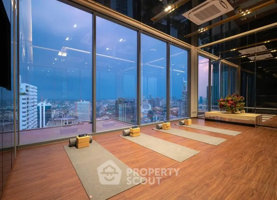 Luxurious high-rise yoga studio with panoramic city views and elegant wooden flooring.