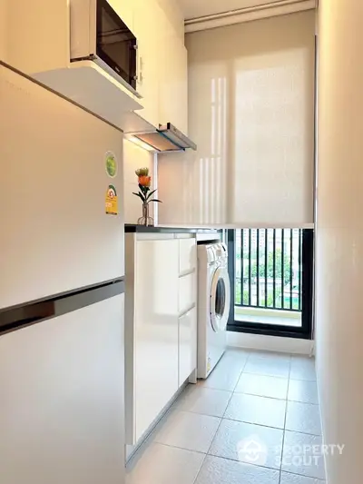 Modern compact kitchen with washing machine and large window view