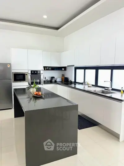 Modern kitchen with sleek design, featuring a large island and built-in appliances, perfect for culinary enthusiasts.