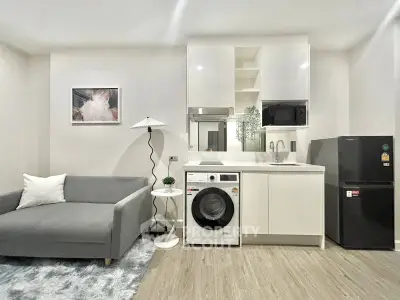 Modern living room with sleek kitchen appliances and cozy seating area