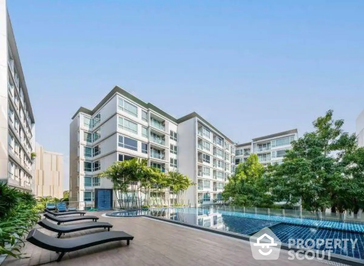 Modern apartment complex with pool and lush greenery, ideal for luxury urban living.