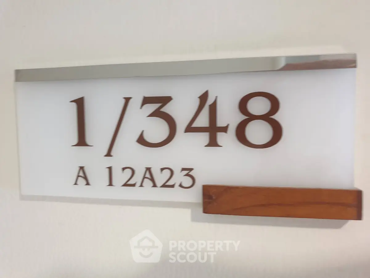 Modern apartment number sign with sleek design and wooden accent, perfect for contemporary living spaces.