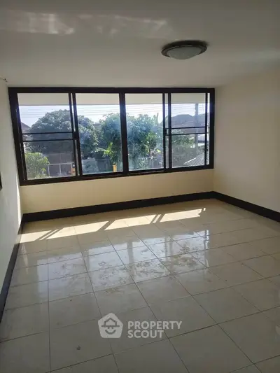 Spacious sunlit room with large windows and tiled flooring, ideal for customization.