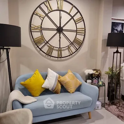 Chic living room with stylish blue sofa and decorative wall clock