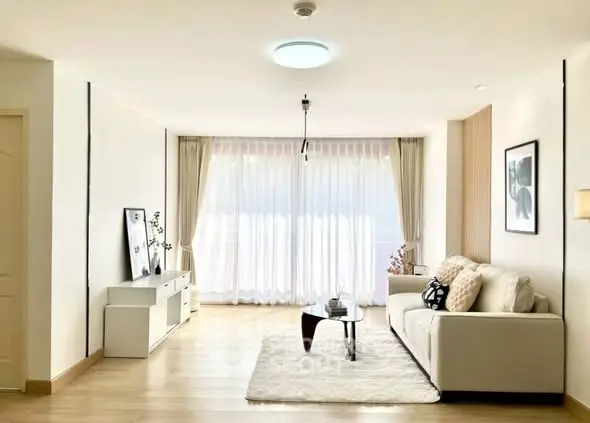 Spacious and bright living room with modern decor and large windows.
