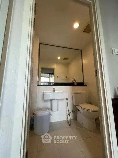 Modern bathroom with sleek fixtures and large mirror in a contemporary home.