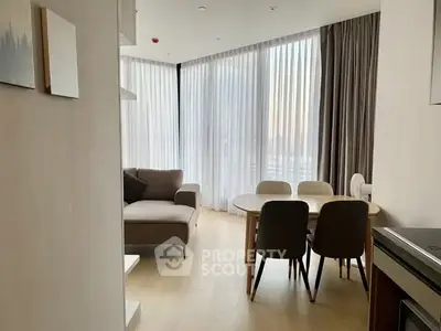 Modern living room with floor-to-ceiling windows and elegant dining area