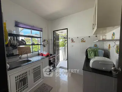 Charming kitchen with open layout and modern appliances, featuring a bright window view.