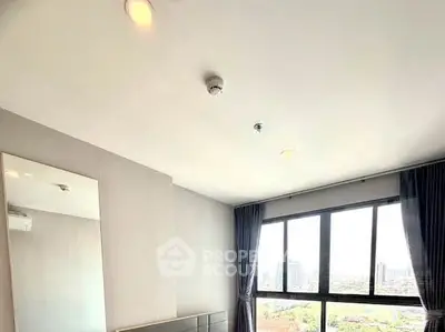 Bright bedroom with large window offering stunning city views and modern decor.