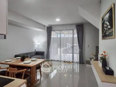 Modern living room with sleek furniture and large window, perfect for cozy gatherings.