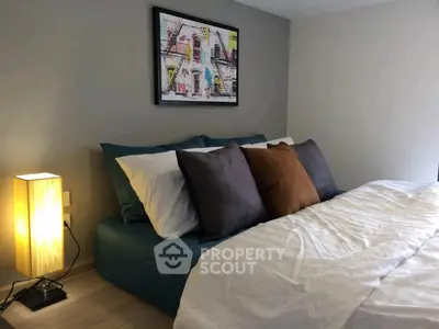 Cozy bedroom with modern decor and stylish artwork above the bed, perfect for relaxation.